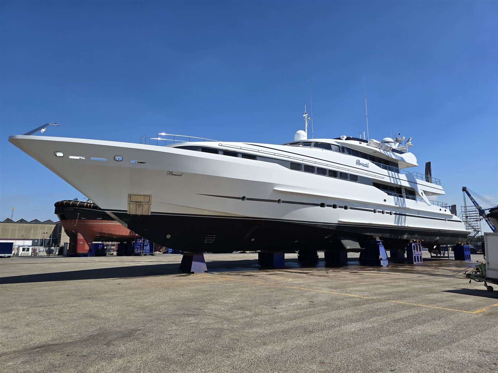 A large motor yacht out of the water on blocks in a boatyard